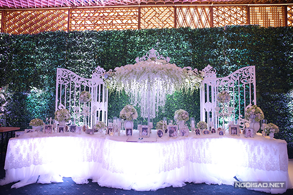 Bàn lễ tân có thiết kế như bước vào một khu vườn cổ tích. Ảnh cưới dễ thương của Trấn Thành và Hari Won được đặt trong những khung ảnh gỗ màu trắng.