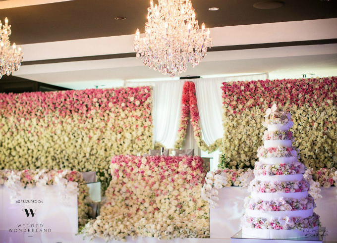 Sân khấu trung tâm được kết bằng hàng nghìn bông hoa hồng. Ngay cả chiếc bánh cưới cũng được tô điểm bởi những dải hoa màu pastel dịu nhẹ. 
